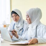 Two woman muslim doctors using a digital tablet, discussing diagnosis deadly disease in Specialized clinics
